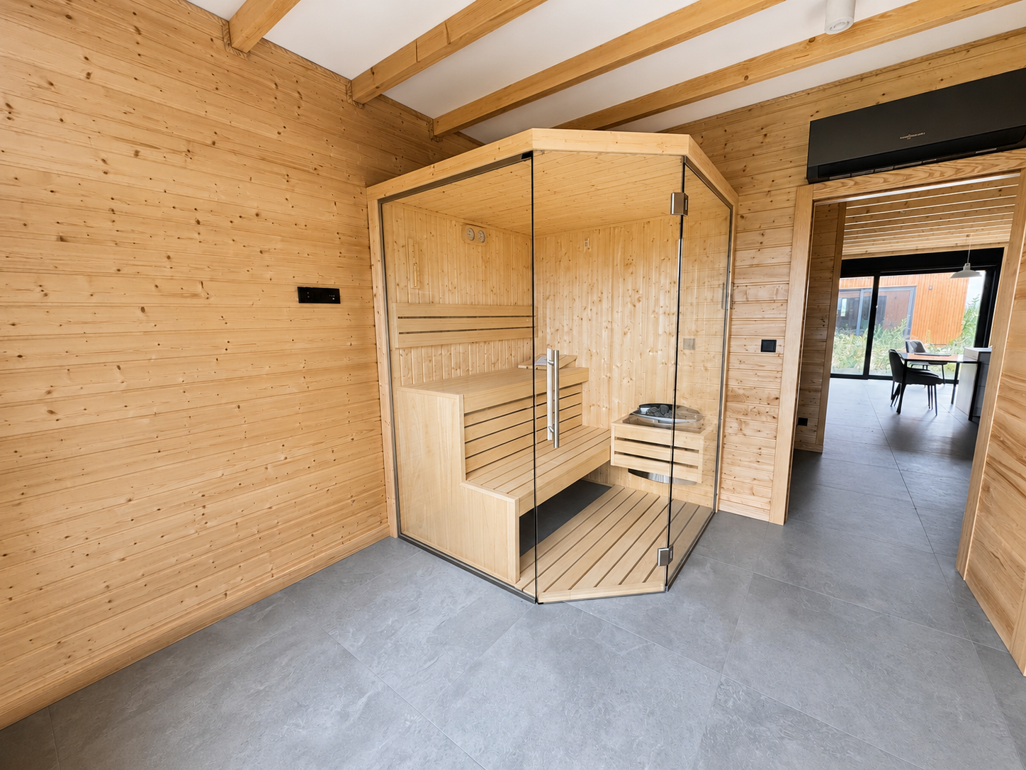Prywatna sauna z drewnianym wykończeniem i przeszklonymi ścianami, stanowiąca komfortową domową strefę relaksu i wellness.
